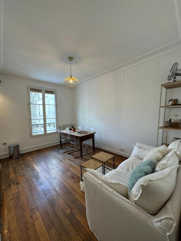 un salon avec un canapé blanc et une table dans l'établissement Appartement situé en plein coeur de Paris, à Paris