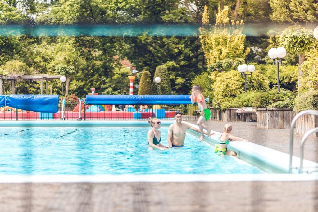 un groupe d'enfants jouant dans une piscine dans l'établissement Veluwepark De Bosgraaf | Comfort met Hottub, à Lieren