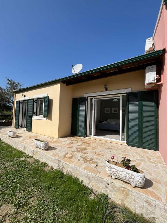 a house with a potted plant in front of it at Kouris Apartment Garden View in Chlomatianá