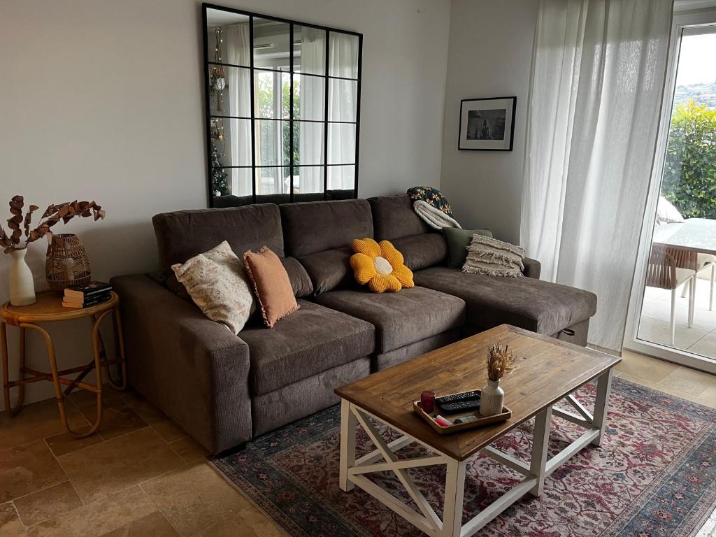 un salon avec un canapé et une table basse dans l'établissement Superbe appartement lumineux en rez de jardin, à Saint-Laurent-du-Var
