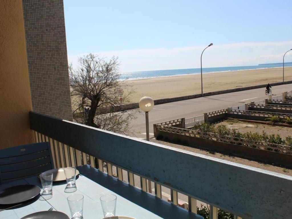 - une table avec des verres à vin et une vue sur la plage dans l'établissement Appartement 2 pièces proche plage, balcon, parking - FR-1-229C-107, à Port-la-Nouvelle