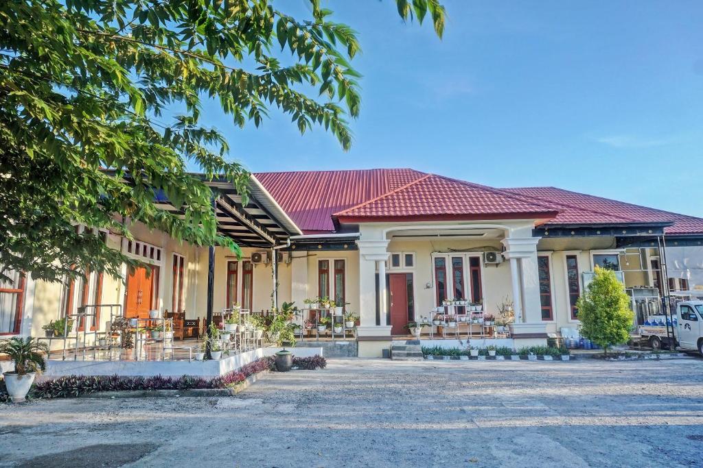 a large house with a red roof at Collection O 91488 Hotel Lingkarsut Jeneponto Near Patung kuda, Jeneponto in Pannara