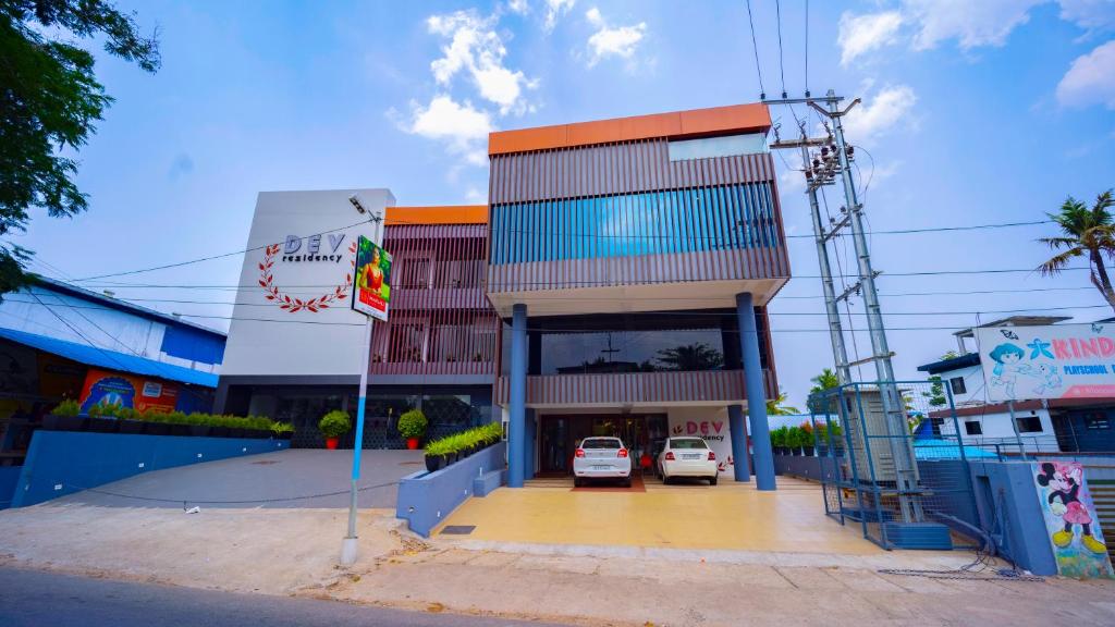 a building with a car parked in a parking lot at Dev Residency in Attingal