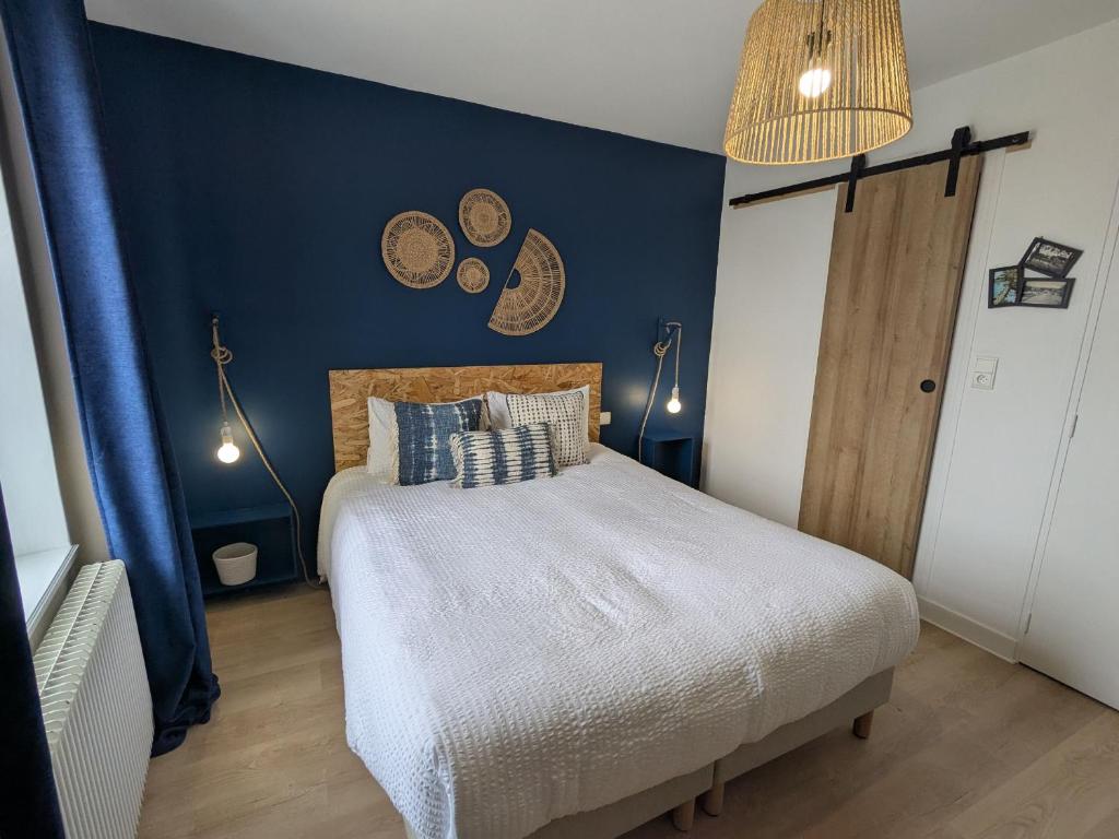 une chambre avec un lit et un mur bleu dans l'établissement Chambre cosy à Briare, centre-ville, idéale pour cyclistes - FR-1-590-571, à Briare