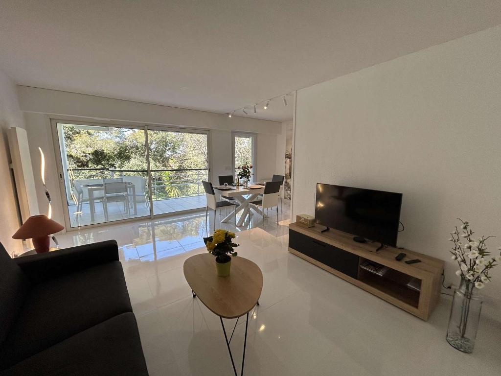 un salon avec une télévision et une table dans l'établissement Appartement moderne à Saint-Raphaël, 2 chambres - FR-1-226A-204, à Saint-Raphaël