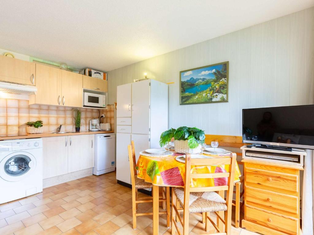 une cuisine avec une table et un réfrigérateur blanc dans l'établissement Appartement calme près du centre Saint-Lary, 700m du téléphérique, 5 pers. max - FR-1-296-516, à Saint-Lary-Soulan