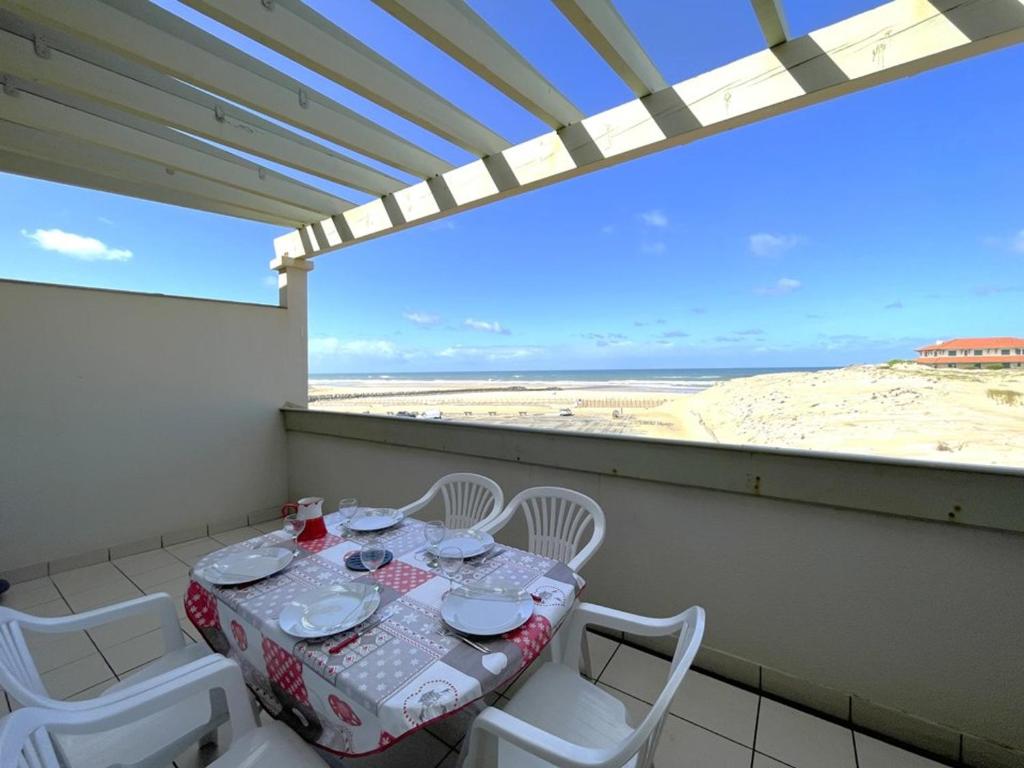 une table et des chaises sur un balcon avec vue sur la plage dans l'établissement T2 Mezzanine, 5 Pers, Face Océan à Vieux-Boucau - FR-1-379-180, à Vieux-Boucau-les-Bains