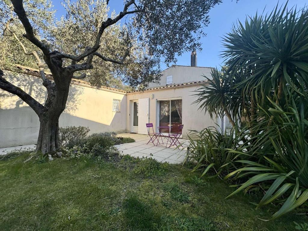 une maison avec une table et des chaises dans une cour dans l'établissement Maison 4 pièces à Saint-Georges-d'Oléron, proche plage - FR-1-246A-347, à Saint-Georges-dʼOléron