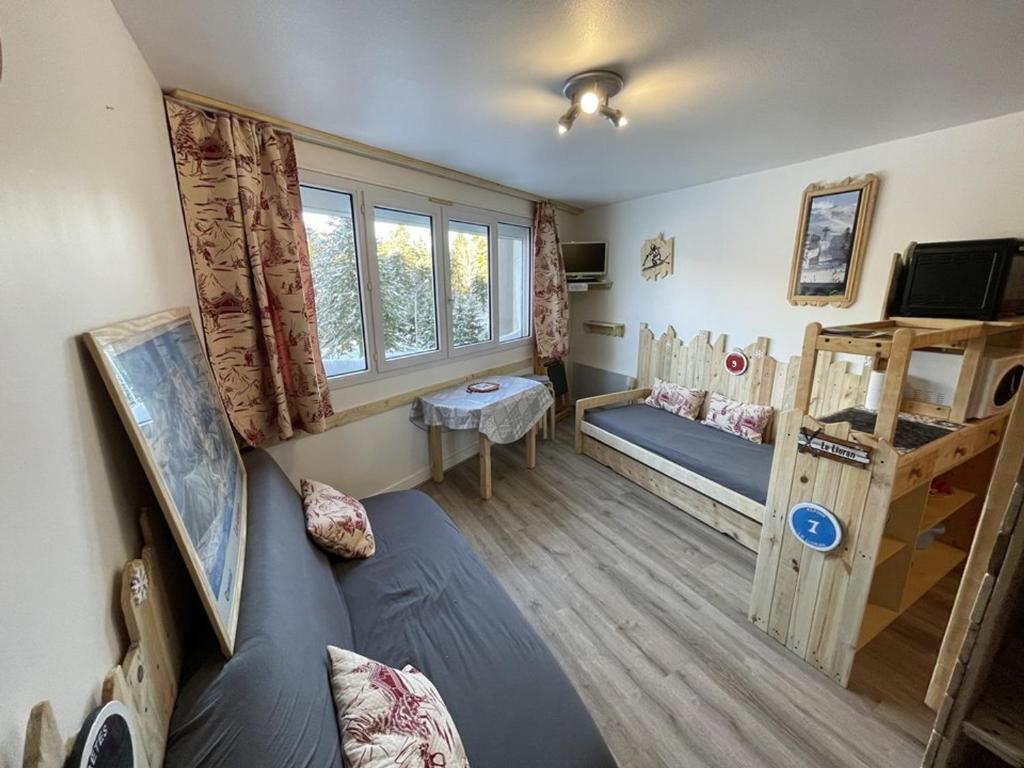 Cette chambre comprend un canapé et des lits superposés. dans l'établissement Coquet T2 au coeur du Lioran - FR-1-787-120, à Laveissière