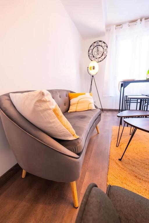 un canapé avec des coussins dessus dans un salon dans l'établissement Découvrez le charme du duplex pour 2 personnes, à Châlons-en-Champagne
