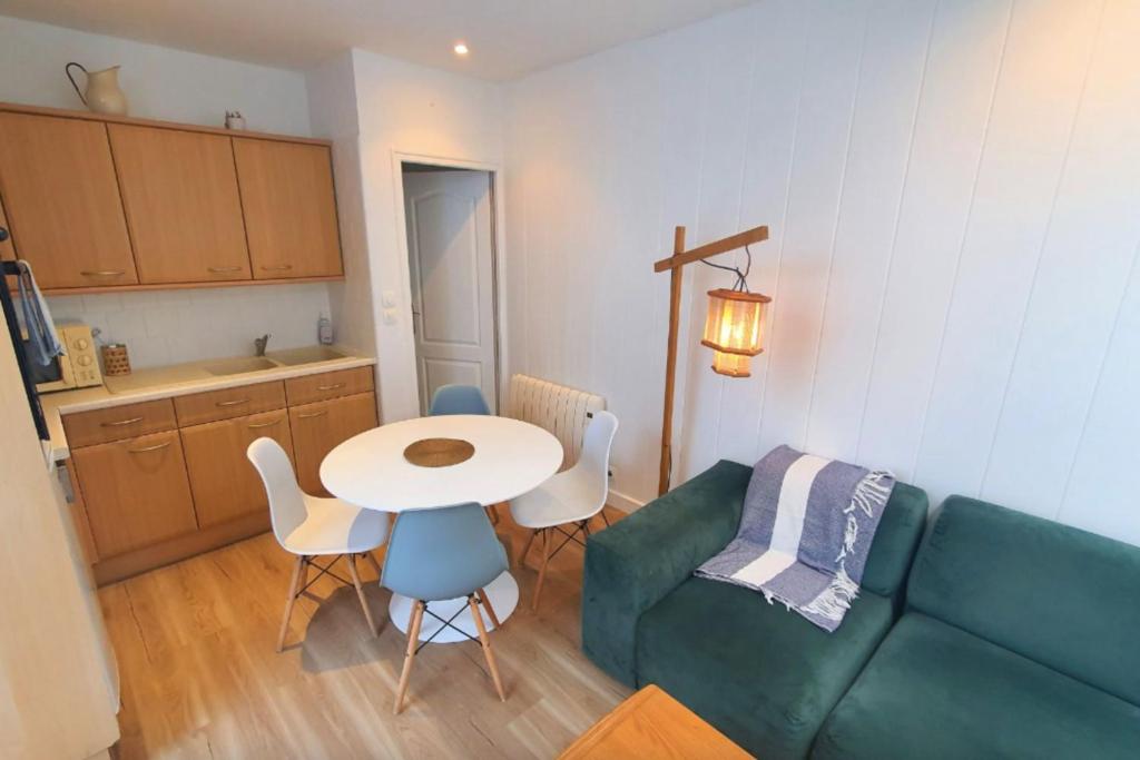 un salon avec un canapé vert et une table dans l'établissement Lovely flat close to the beach, à Saint-Malo
