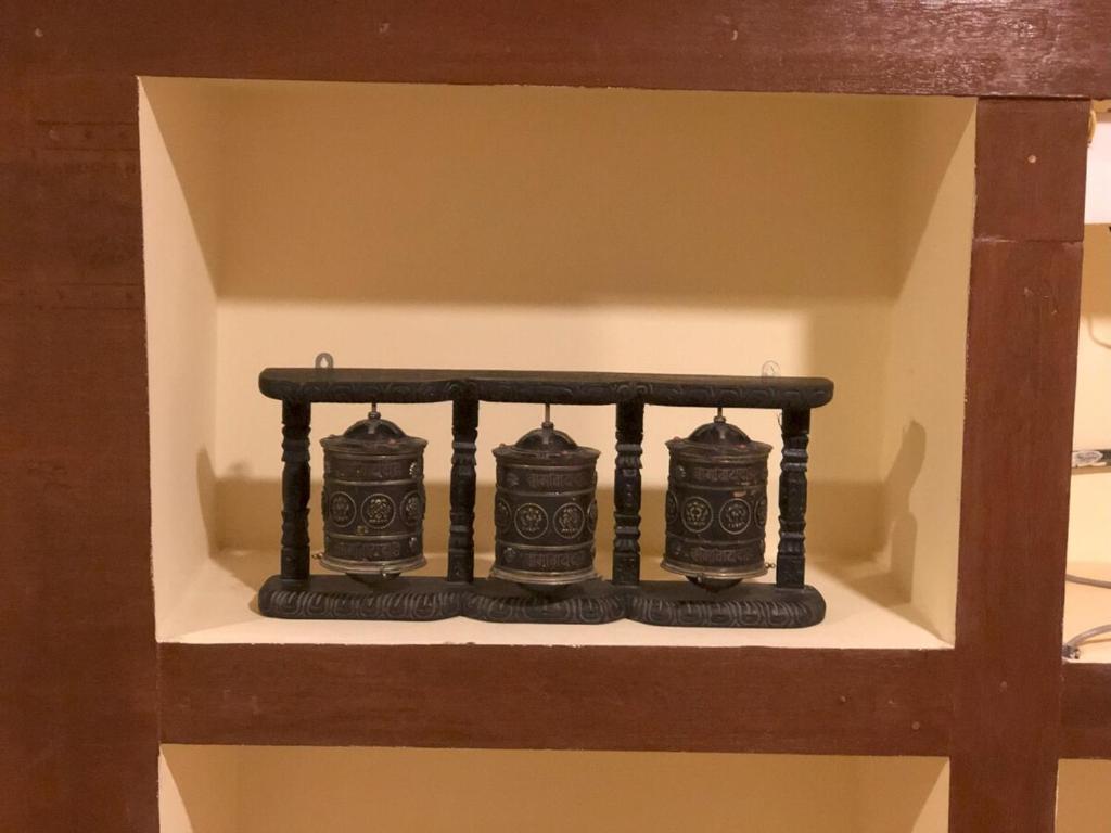 a shelf with four black candles on it at Zenith Apartments Thamel - Manaslu 1BHK Apartment in Kathmandu