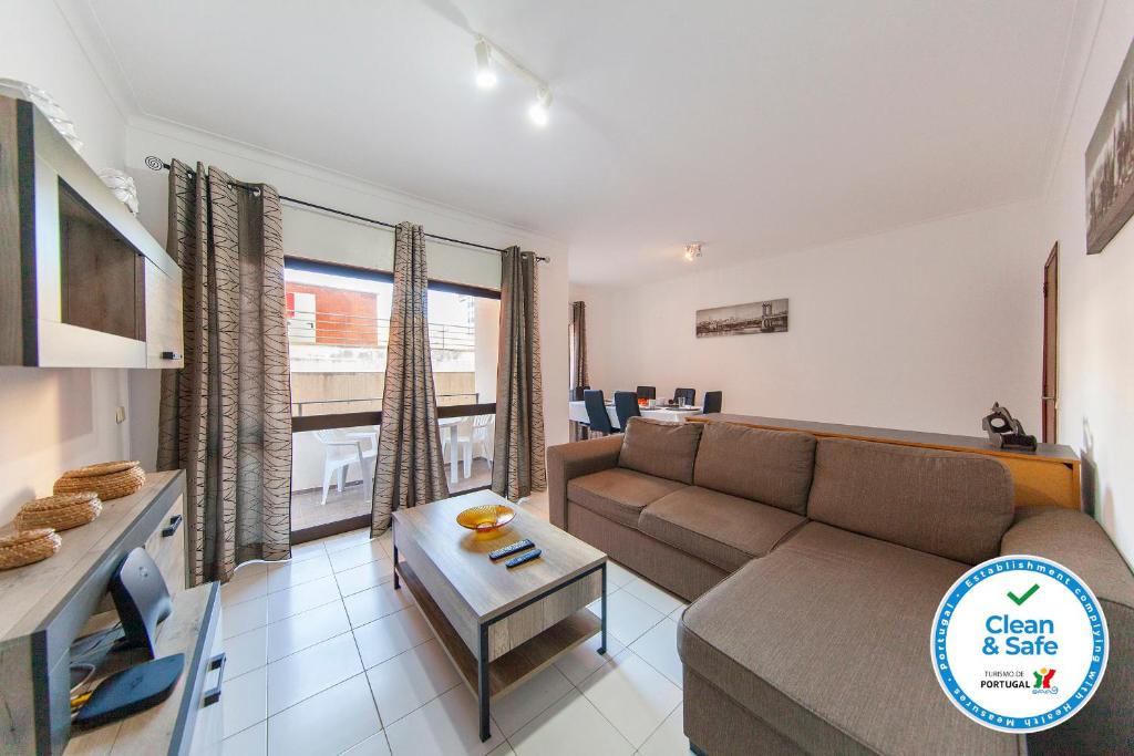 a living room with a couch and a table at Rio a Vista Praia da Rocha Flat in Portimão