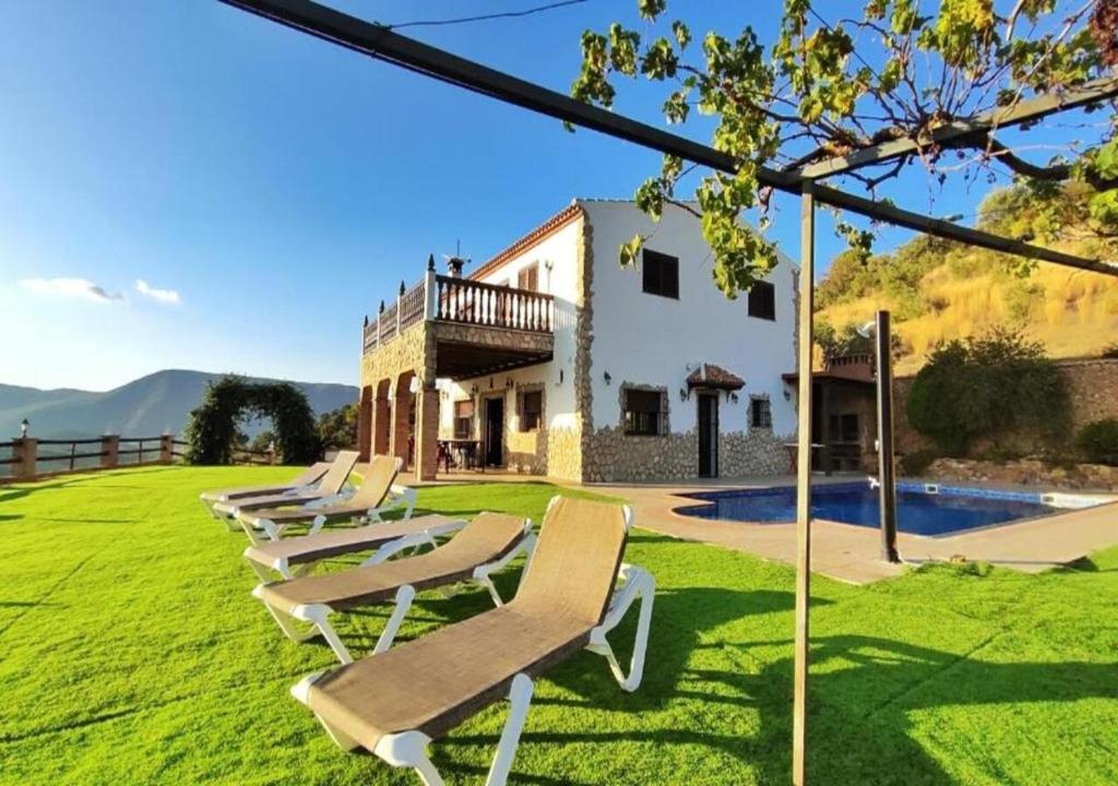 a row of lounge chairs in front of a building at Villa 10 by Villamya in El Gastor