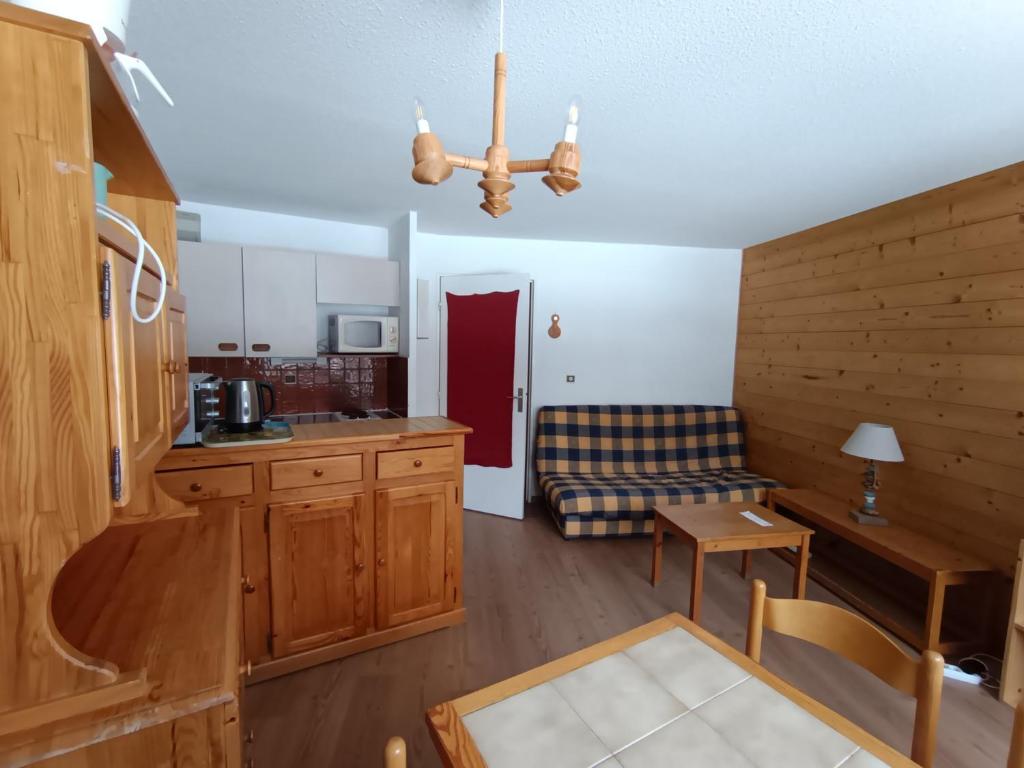 une cuisine et un salon avec un canapé et une table dans l'établissement Montgenèvre - Appartement sur les pistes 4-6 pers., balcon sud-ouest, animaux acceptés - FR-1-445-107, à Montgenèvre