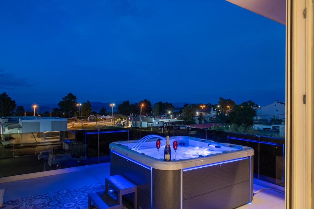 科孚镇Alykes Houses - Prv Jacuzzi的阳台的按摩浴缸(晚上)