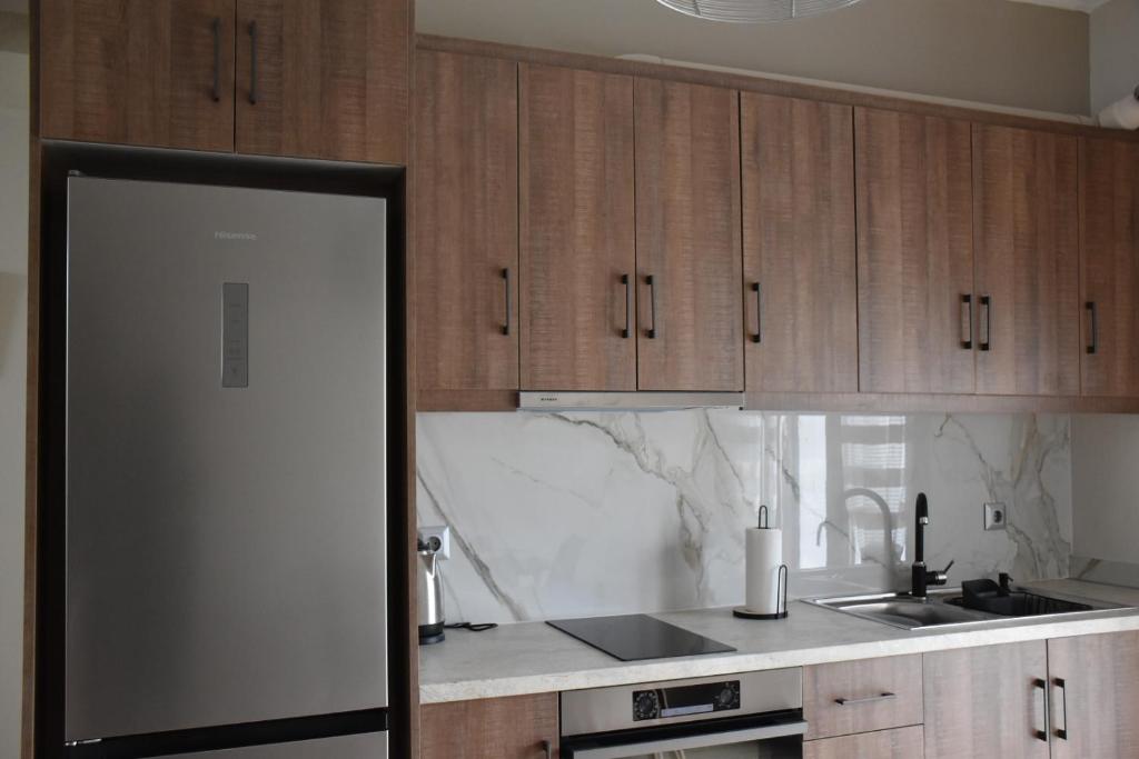 a kitchen with wooden cabinets and a counter top at Niki's cozy apartment in Mytilene