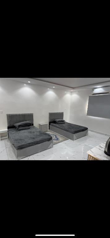 two beds sitting in a room with a wall at MOUNTAIN HoTEL in Al Bad‘