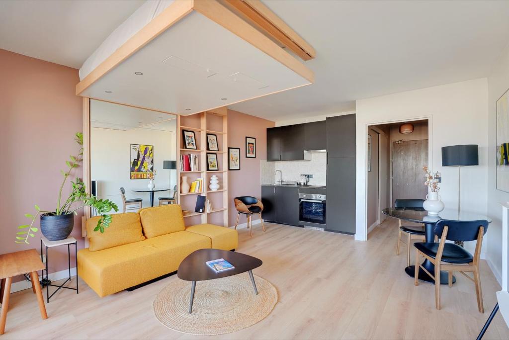 un salon avec un canapé jaune et une table dans l'établissement Studio refait à neuf avec balcon et vue sur la Seine - bail mobilité, à Paris