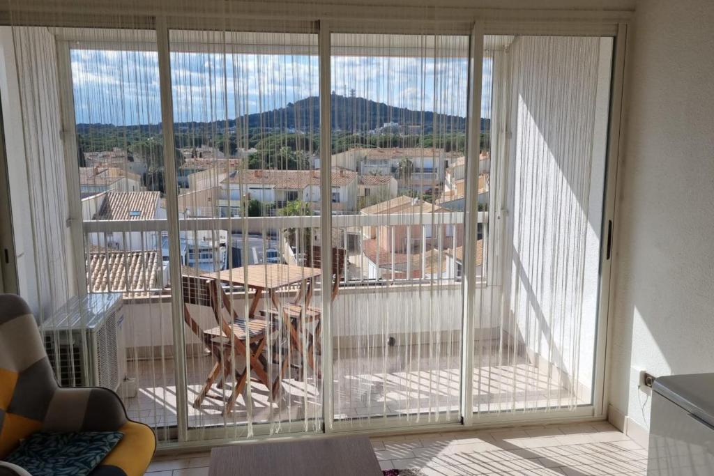 un balcon avec une table et une vue sur une ville dans l'établissement Naturiste Cap d'Agde Port Soleil 589, au Cap d'Agde