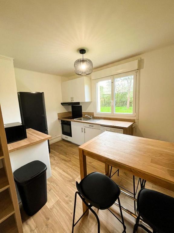 - une cuisine avec une table et des chaises en bois dans la chambre dans l'établissement Appartement Moderne 3 Chambres 62 m2 - Saint-Brieuc, à Saint-Brieuc