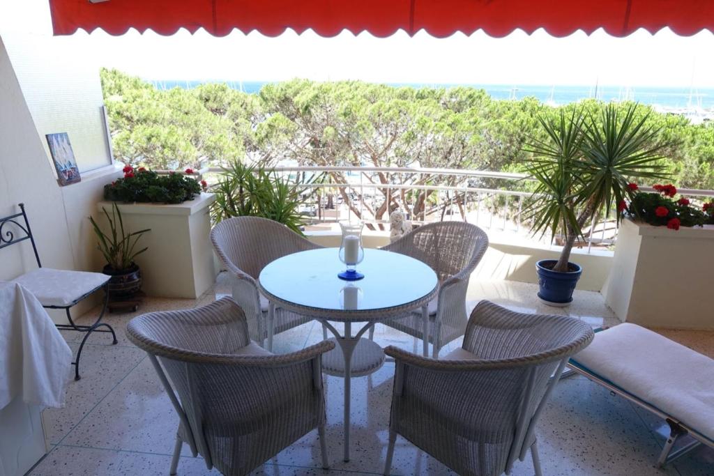 une terrasse avec une table et des chaises ainsi qu'une grande fenêtre. dans l'établissement MAGNIFICENT SEAFRONT Studio, à Mandelieu-la-Napoule
