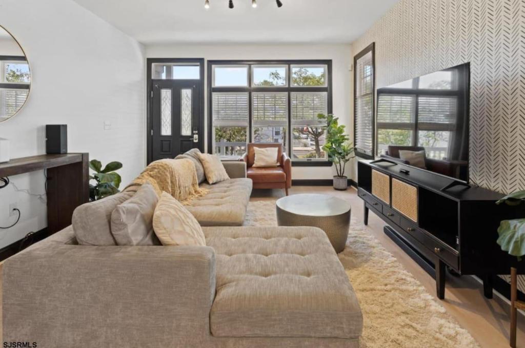 a living room with two couches and a piano at Chic Haven- Close to Beach, Boardwalk & Casinos in Atlantic City