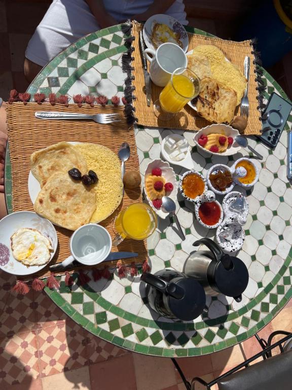 a table with plates of food and glasses of orange juice at Riad Mamma MARRAKESH in Marrakesh