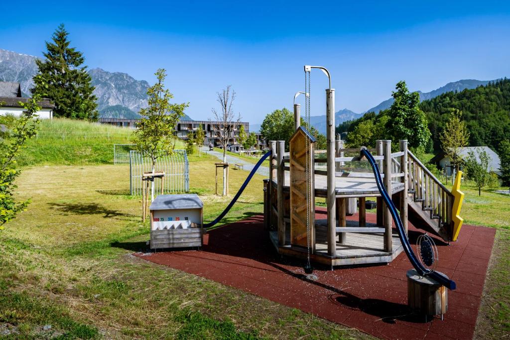 a park with a playground with a swing at Falkensteiner Family Hotel Montafon - The Leading Hotels of the World in Schruns-Tschagguns