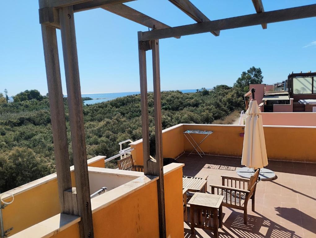 a view from the balcony of a house with an umbrella at Apartamento Vera-playa in Los Amarguillos
