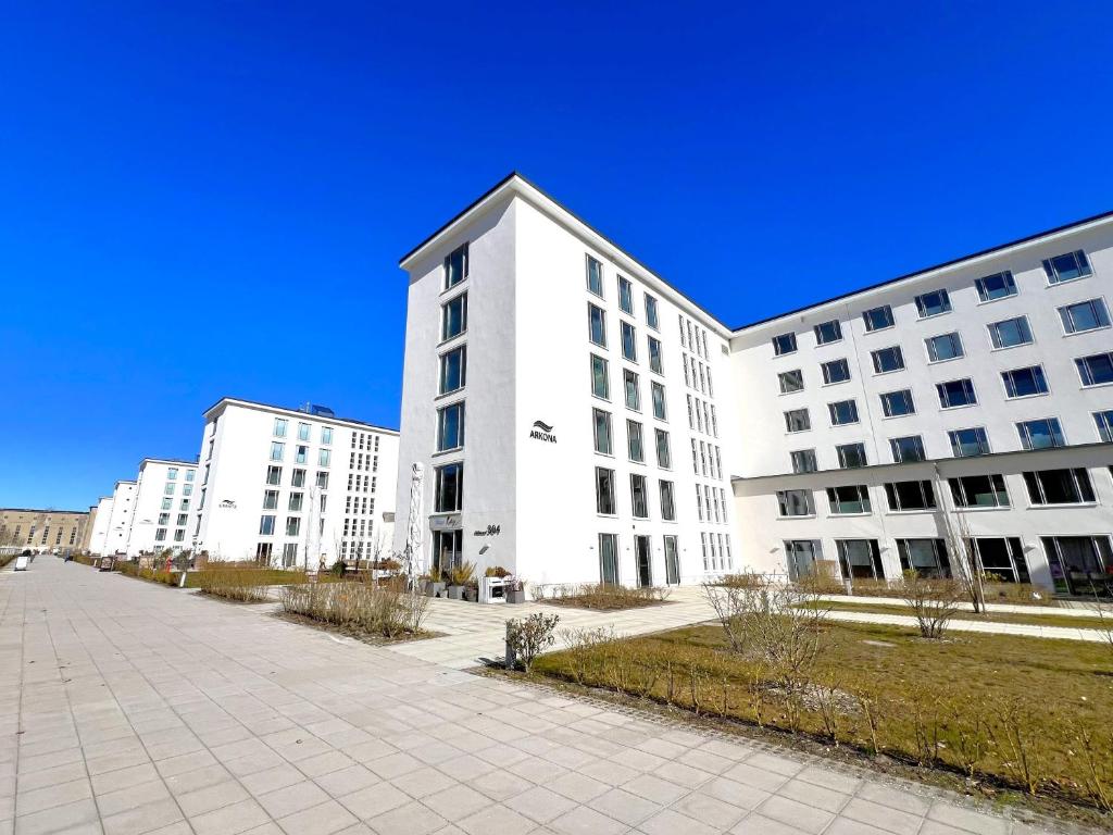 two white buildings with a sidewalk in front of them at Haus Arkona - Apartment Seestern - 5 2 in Prora