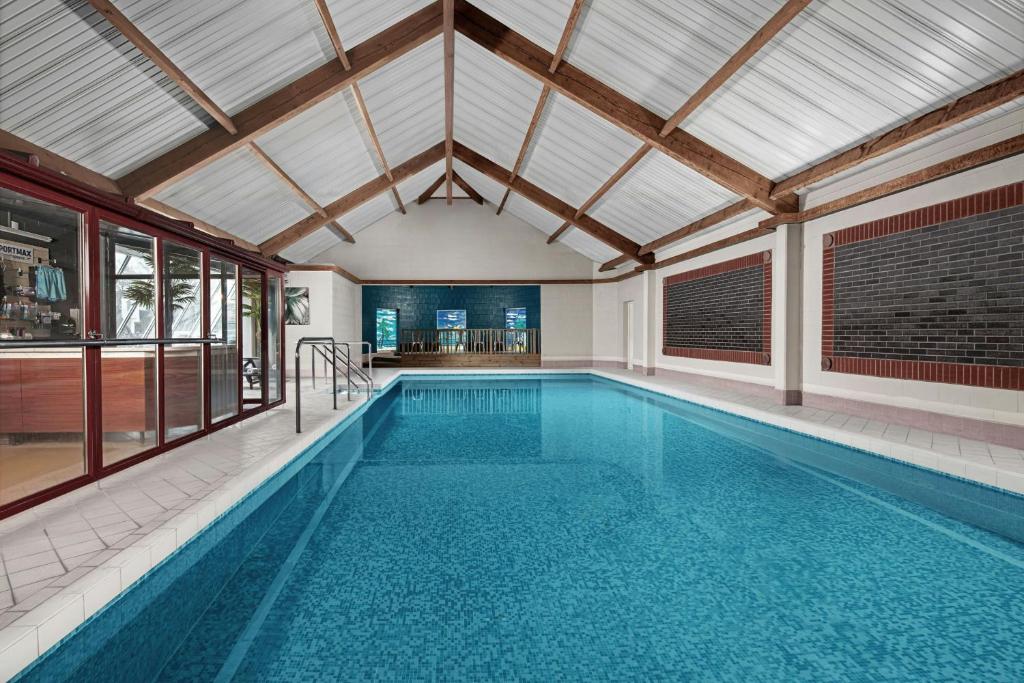 an indoor swimming pool with a large ceiling at Delta Hotels by Marriott Colchester in Colchester