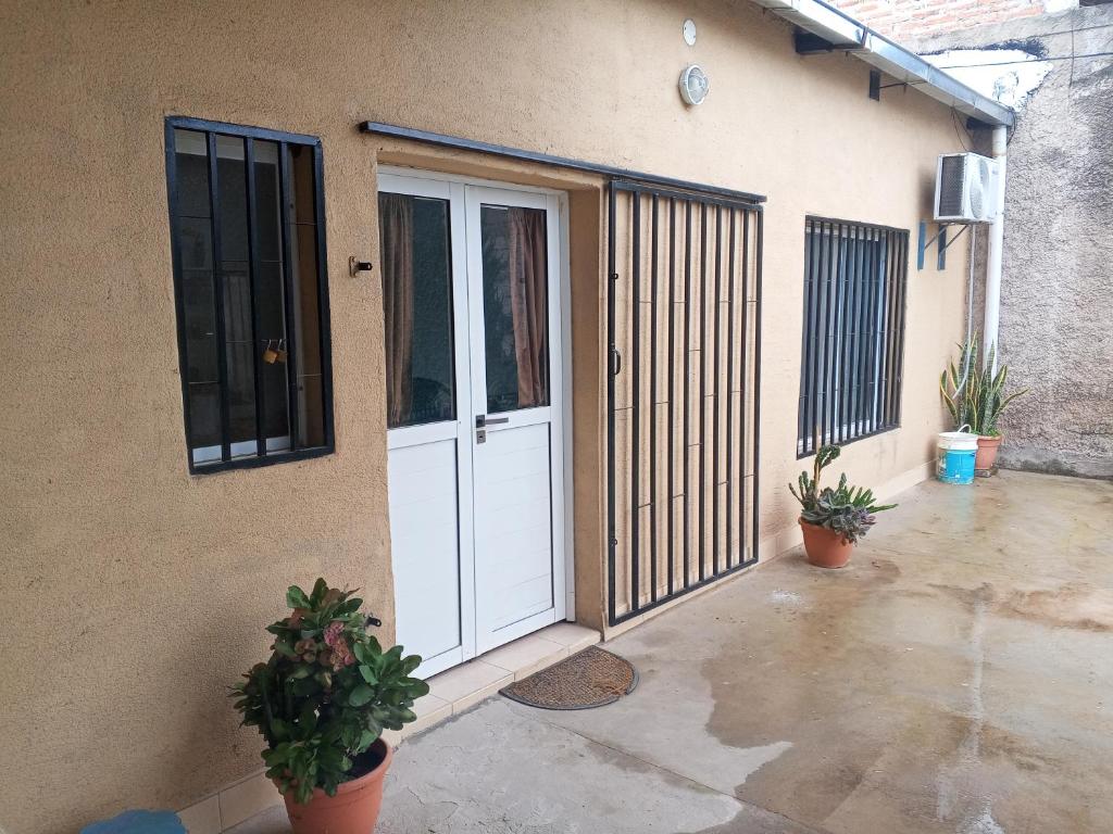 a white door on the side of a building with plants at Alojamiento Temporario Sol de las Yungas in Libertador General San Martín