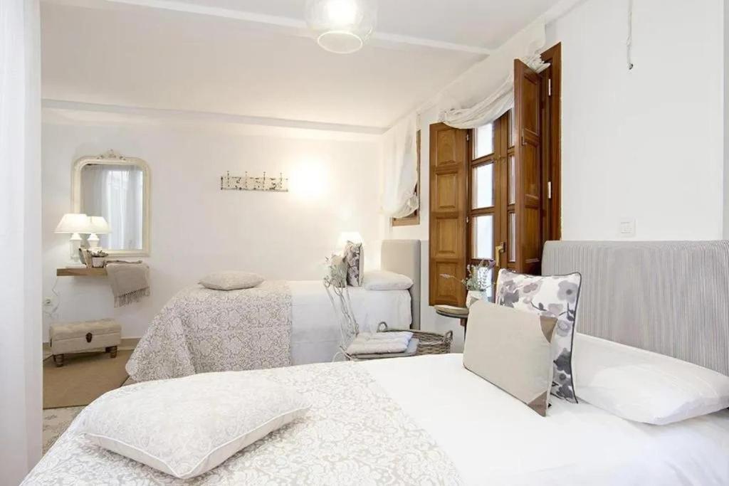 Postel nebo postele na pokoji v ubytování Apartamentos LA TONÁ Puerta Elvira centro ciudad