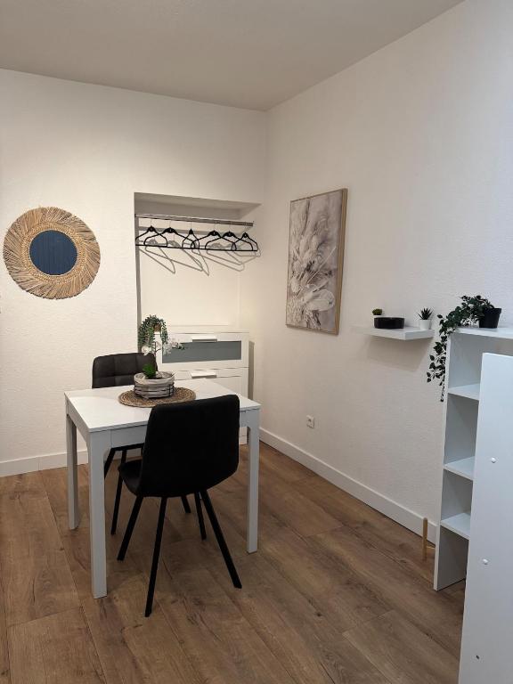 une salle à manger avec une table et des chaises blanches dans l'établissement Appartement centre ville, à Lure