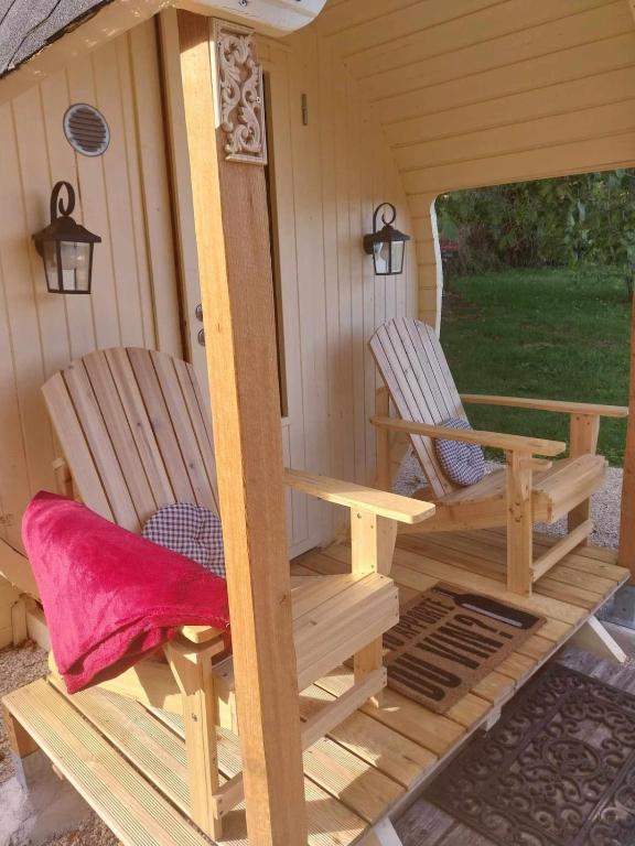 une cabine avec 2 chaises sur la terrasse couverte dans l'établissement Tonneau Vacances Insolites, à Véria