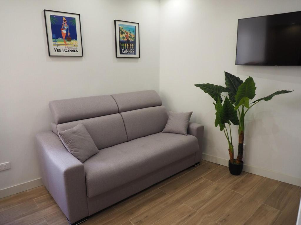 un canapé dans un salon avec une télévision dans l'établissement Charmant studio, quartier historique, à Cannes