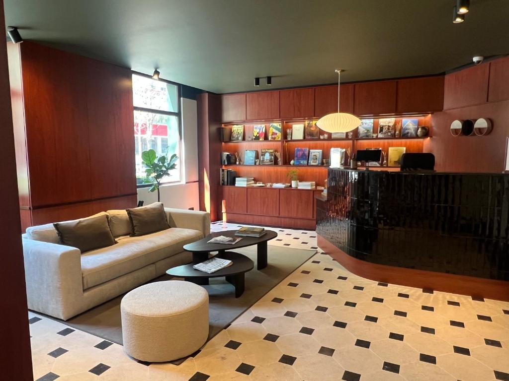 un salon avec un canapé et une table dans l'établissement Hôtel Marguerite, à Paris