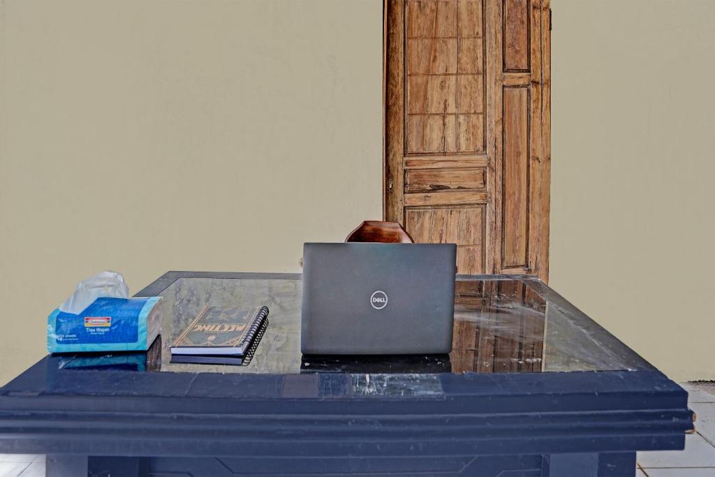 a table with a laptop computer on top of it at Hotel O Villa A1 in Tretes