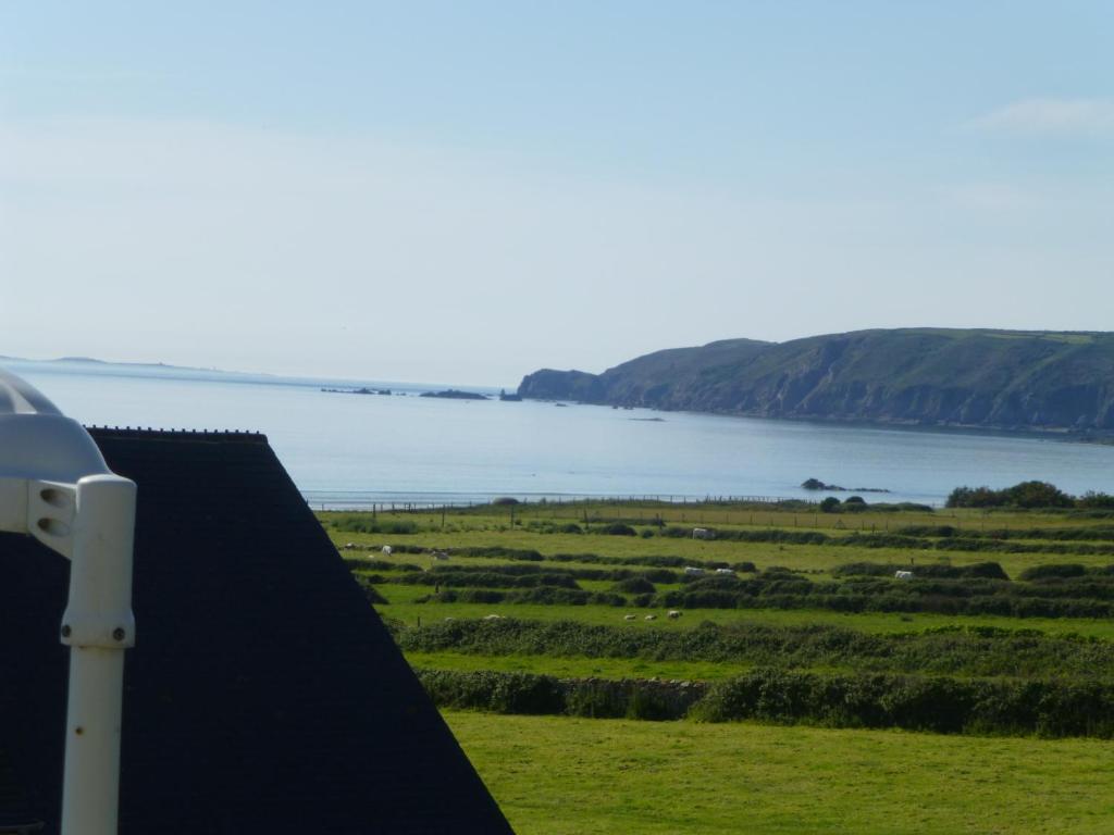 - une vue sur l'eau depuis le toit d'une maison dans l'établissement Gîte belle Rîve, à Vauville