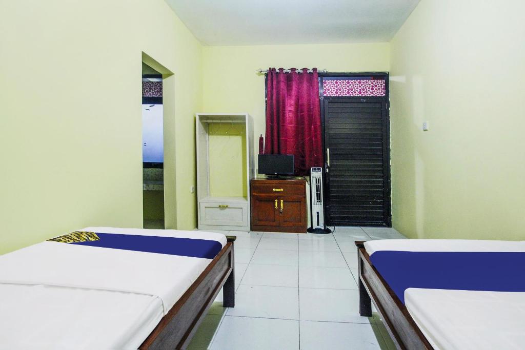 Postel nebo postele na pokoji v ubytování OYO Life 91606 Nadin Guest House Syariah