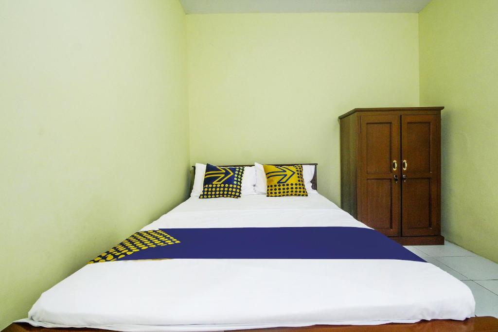 Postel nebo postele na pokoji v ubytování OYO Life 91606 Nadin Guest House Syariah