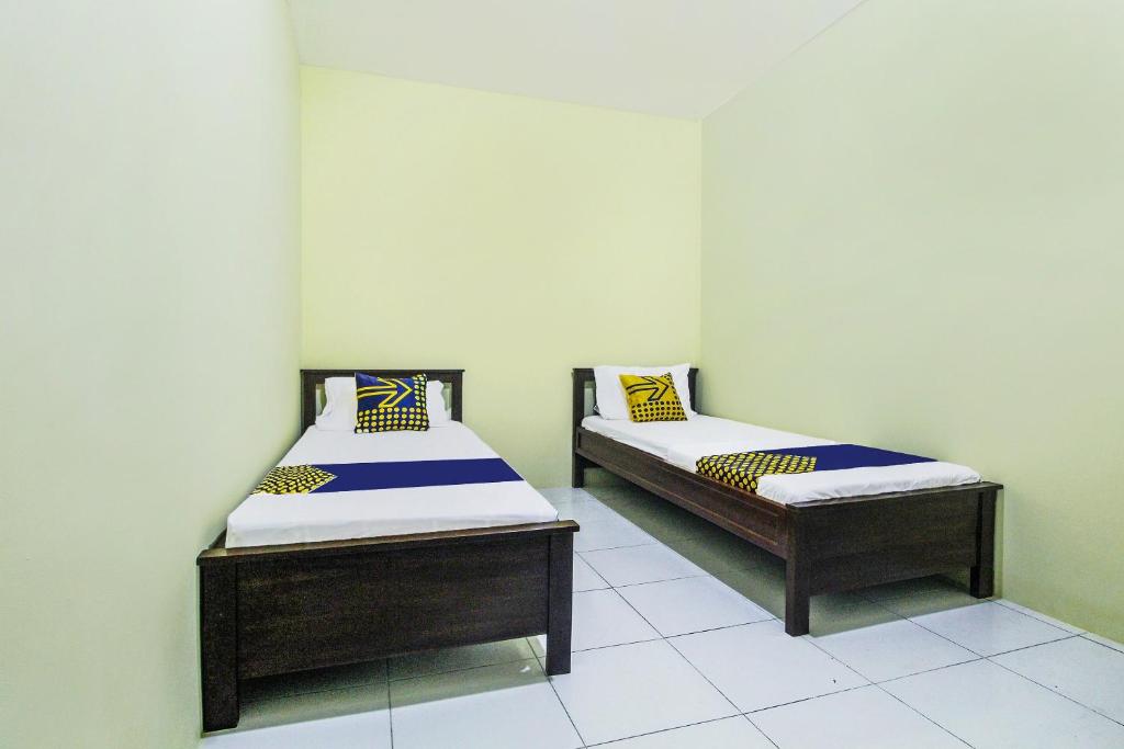 Postel nebo postele na pokoji v ubytování OYO Life 91606 Nadin Guest House Syariah