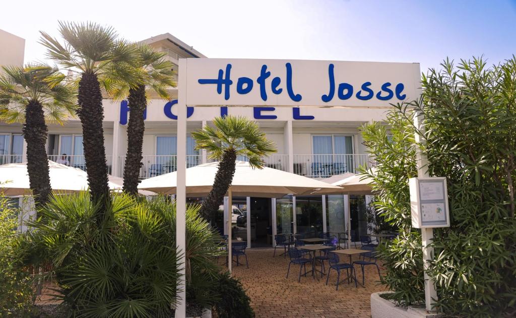 a hotel with palm trees in front of a building at Hôtel Josse in Antibes