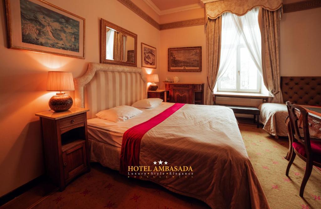 ブンツラウにあるHotel Ambasada Bolesławiecのベッドと窓のあるホテルの部屋
