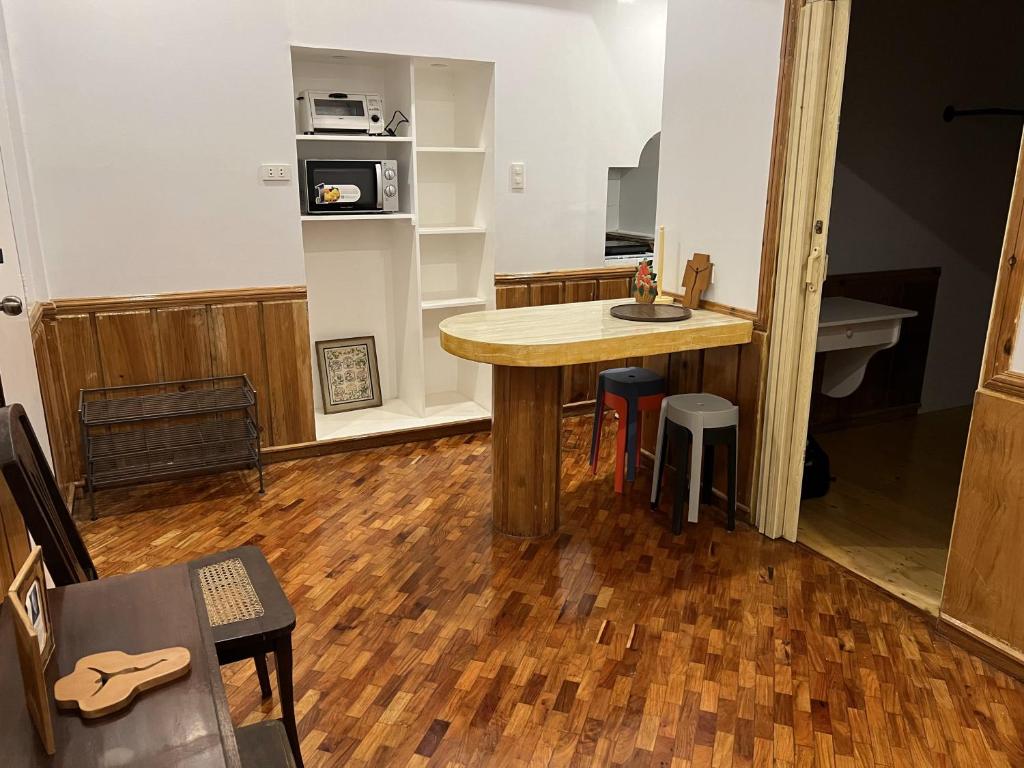 a kitchen with a wooden table in a room at Condo in Green Valley Baguio in Baguio