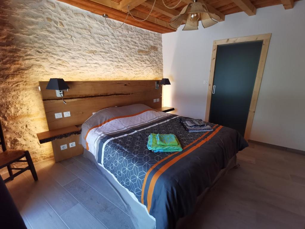 une chambre avec un grand lit avec une tête de lit en bois dans l'établissement Lou fredou, à Saint-Amand-de-Coly