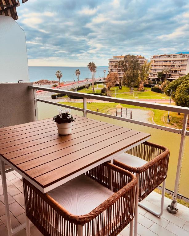a wooden table on a balcony with a view of the ocean at Casa Paloma in Ventimiglia
