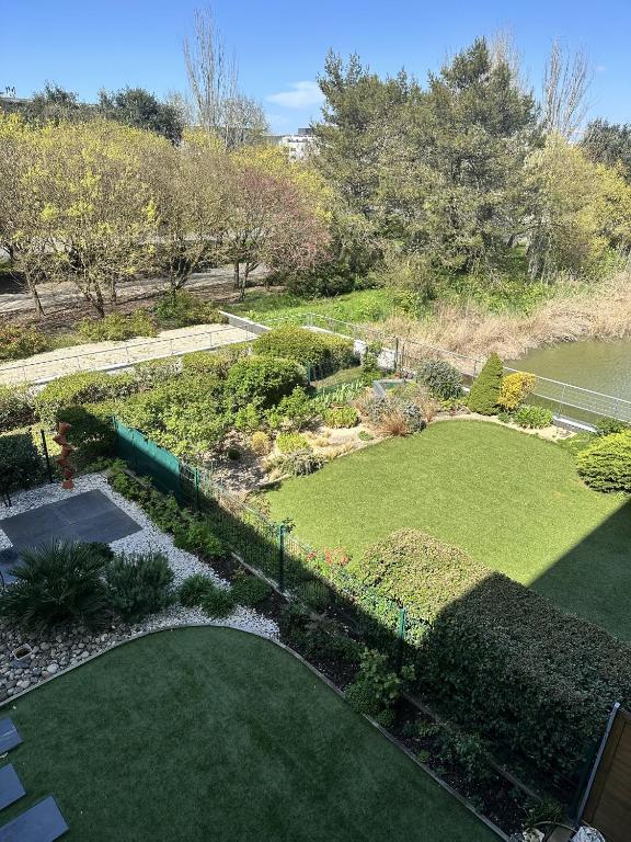 - une vue aérienne sur un jardin avec une pelouse dans l'établissement Proche mer, terrasse et wifi, aux minimes, à La Rochelle