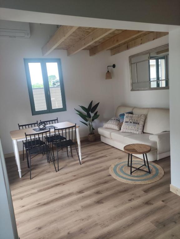 un salon avec un canapé et une table dans l'établissement La Perlilounette, à Le Porge